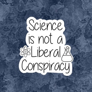 May include: A white sticker with black text and illustrations on a blue background. The text reads "Science is not a Liberal Conspiracy". The illustrations are a stylized atom and a beaker.