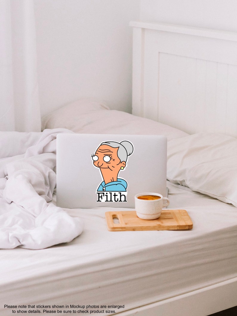 May include: A laptop computer with a sticker of a cartoon woman with grey hair and a blue hoodie. The sticker says "Filth".