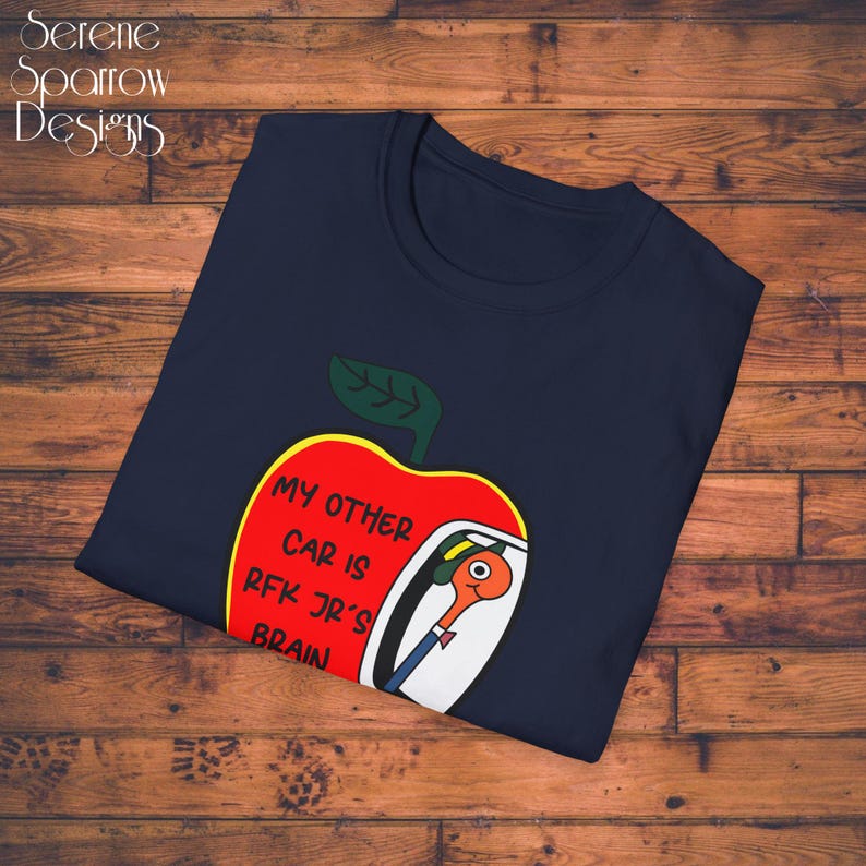 May include: A navy blue t-shirt with a red apple graphic. The apple has a white car inside with the text "My other car is RFK Jr's brain".