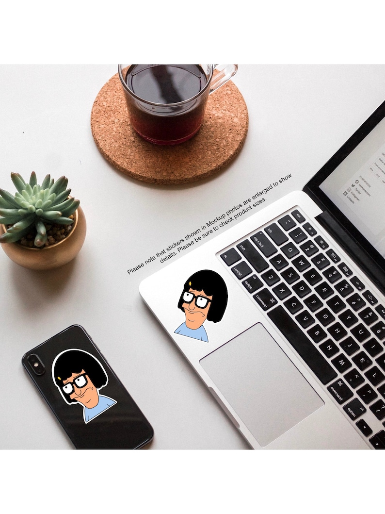 Puede incluir: Dos pegatinas con un personaje de dibujos animados con cabello negro, gafas y una camisa azul. Las pegatinas est&aacute;n en una computadora port&aacute;til y una funda de tel&eacute;fono negra.