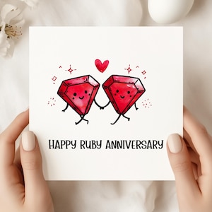 Può includere: Un biglietto bianco con la scritta "HAPPY RUBY ANNIVERSARY" tenuto in mano. Il biglietto presenta due gemme rosse dei cartoni animati che si tengono per mano, con un cuore rosso sopra. Le gemme hanno facce sorridenti e sono circondate da piccole scintille.