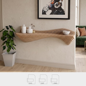 May include: A contemporary wooden shelf with a wave design, fixed to a light wall. It displays two white vases, a small bowl, and sprigs. A framed artwork is above the shelf. A potted plant is on the left.