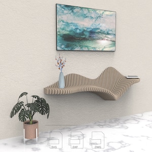 Puede incluir: Una estantería de pared de madera con un diseño ondulado. La estantería está hecha de madera marrón claro y tiene un acabado natural. La estantería está montada en una pared blanca y tiene un jarrón con flores en ella. La estantería también está decorada con una pintura de un paisaje azul y verde.