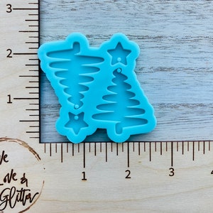 May include: A blue silicone mold for making Christmas tree ornaments. The mold has two tree shapes and a star shape.
