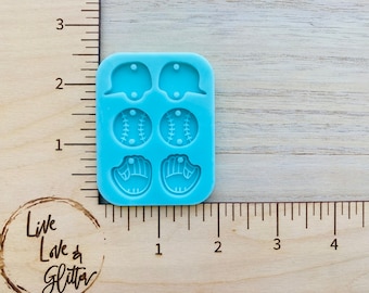 May include: A blue silicone mold with six cavities for making baseball-themed resin crafts. The mold features two baseballs, two baseball gloves, and two baseball caps.