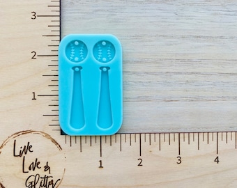May include: A light blue silicone mold with two baseball and bat shapes. The mold is approximately 2 inches tall and 1 inch wide.