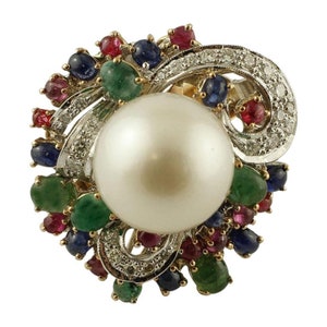 May include: A large, white pearl ring with a gold setting. The ring is adorned with a cluster of colorful gemstones, including emeralds, rubies, and sapphires.