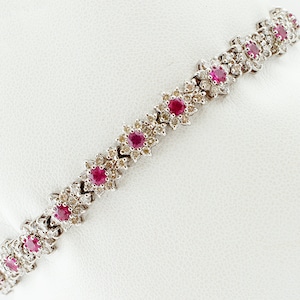 Puede incluir: Un brazalete de oro blanco con un diseño floral con rubíes rojos y diamantes.