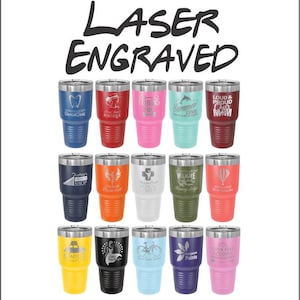 May include: A collection of laser-engraved insulated tumblers in various colors, including blue, red, pink, teal, and maroon. Each tumbler features a different design or logo, such as "Dental Clinic," "Summer Cove," and "LOUD & PROUD Cheer MOM."