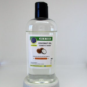 Op de afbeelding: Een doorzichtige glazen fles met een zwarte dop die kokosolie bevat. Het etiket is wit met groene tekst die "AYU FARM Rosky COCONUT OIL COSMATIC GRADE 100% NATURAL ODORLESS NON-SOLIDIFYING FORMULA FOR EXTERNAL USE ONLY MANUFACTURED BY MY SWEET DREAM ANTIOCH CA 94509 www.roshycosmetics.com MADE IN USA" luidt. Er zijn twee kokosnoten op het etiket.
