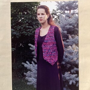 Può includere: Una donna indossa un gilet viola e rosa realizzato con una tecnica di tessitura con spilli. Il gilet è mostrato in cinque viste diverse. L'immagine include il testo "Pin-Weaving for Vests #701 Large and Extra Large".