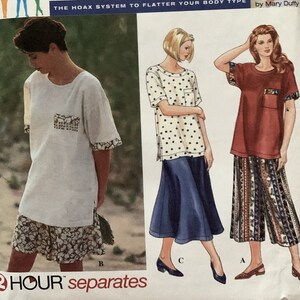Pode incluir: Padrão Simplicity 9535 para uma blusa e uma saia para uma figura cheia. O padrão inclui três estilos diferentes: uma blusa branca com um bolso floral, uma blusa de bolinhas com uma saia azul e uma blusa vermelha com uma saia estampada. O padrão é rotulado como "Full Figure Solutions" e "The Hoax System to Flatter Your Body Type" por Mary Duffy.