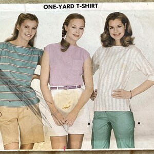 May include: Butterick pattern 3752 for a one-yard T-shirt. The image shows three women modeling different shirt styles. The pattern includes a striped top, a solid-colored top, and a three-quarter sleeve striped shirt. The size is medium.