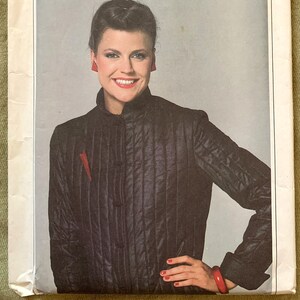 May include: Simplicity sewing pattern number 9305 for a black quilted jacket. The pattern is for sizes 12, 14, and 16. The pattern is labelled "Extra-Sure Pattern" and is part of the ESP line.
