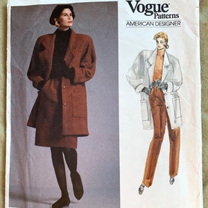 May include: A vintage Vogue Patterns sewing pattern for a coat, featuring a brown coat with a skirt and a white coat with brown trousers. The pattern is labelled "Tamotsu" and "Easy/Facile" with the pattern number 1953.
