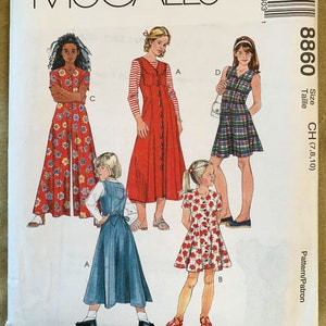 May include: A sewing pattern for four different dresses for girls. The pattern is for sizes 7, 8, and 10. The dresses are all different styles, with some having floral prints and others having plaid patterns.