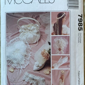 May include: A wedding sewing pattern with instructions for making a bridal bouquet, garter, pillow, gloves, and headpiece. The pattern is from McCall's and is called Alicyn Exclusives.