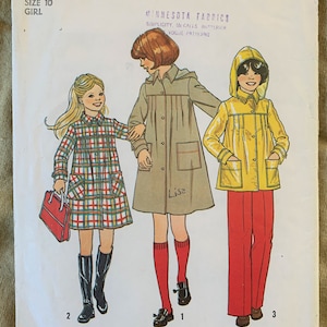 May include: A vintage sewing pattern for a girl's raincoat, dress, and pants. The pattern is from Simplicity and is number 7948. The pattern includes instructions for making a plaid dress, a yellow raincoat, and red pants.