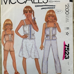 May include: A vintage sewing pattern for girls' clothing. The pattern is for a sleeveless top with a lace trim and a skirt or pants. The pattern number is 7523 and the size is 6.