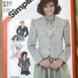 May include: A sewing pattern for a blazer with puff sleeves. The pattern is from Simplicity and the pattern number is 5573. The pattern includes instructions on how to work with plaids.