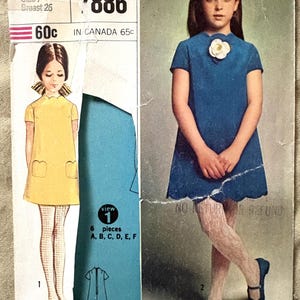 Puede incluir: Patrón de costura Simplicity vintage para un vestido de niña, talla 7, contorno de pecho 66 cm. El patrón presenta ilustraciones del diseño del vestido e incluye el texto "DESIGNER FASHION".