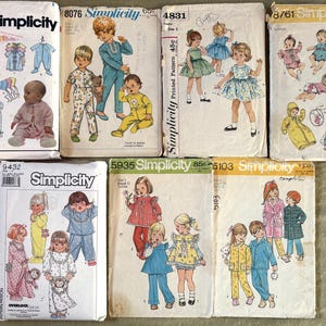 Pode incluir: Uma coleção de padrões de costura Simplicity vintage para roupa infantil. Os padrões apresentam ilustrações de bebés e crianças em várias roupas, incluindo pijamas, vestidos e roupa exterior. Os padrões são em vários tamanhos e estilos.