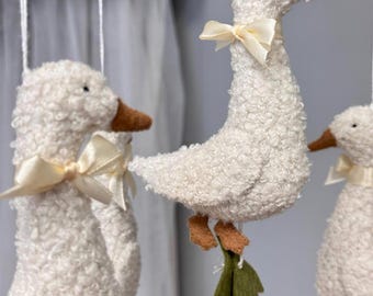 Silly Goose babymobiel met kokette strikjes en madeliefjesbloem.