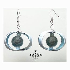 May include: White oval earrings with a gray felt ball and a white pearl bead hanging inside each oval.