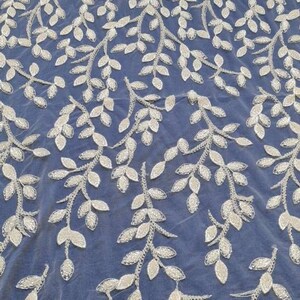 May include: White beaded lace fabric with a delicate leaf pattern on a blue background.