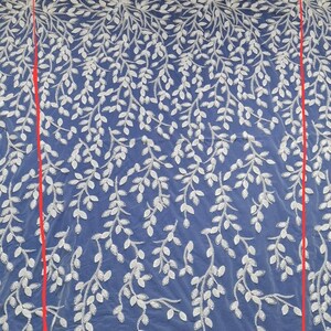 May include: White embroidered lace fabric with a delicate leaf pattern on a blue background. The fabric is 1 meter wide.