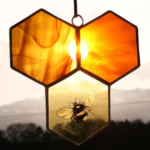 A delicate hand painted honey bee & honeycomb suncatcher. Gold amber honey swirls of stained glass. A unique mother nature inspired bee gif