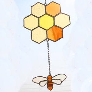 Handgefertigte bernsteinfarbene und goldfarbene Honigbiene hängt an einem wabenförmigen Glasmalerei-Sonnenfänger. Ein perfektes Geburtstagsgeschenk für Bienenliebhaber oder Einweihungspartygeschenk