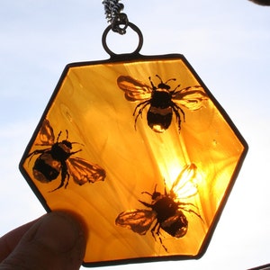Delicate hand painted honey bees on an wispy amber honeycomb. A unique mother nature inspired bee gift. A handmade stained glass suncatcher