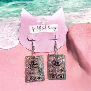 Brincos de resina com glitter pastel roxo e carta de tarô Pink Beach Death Kitty