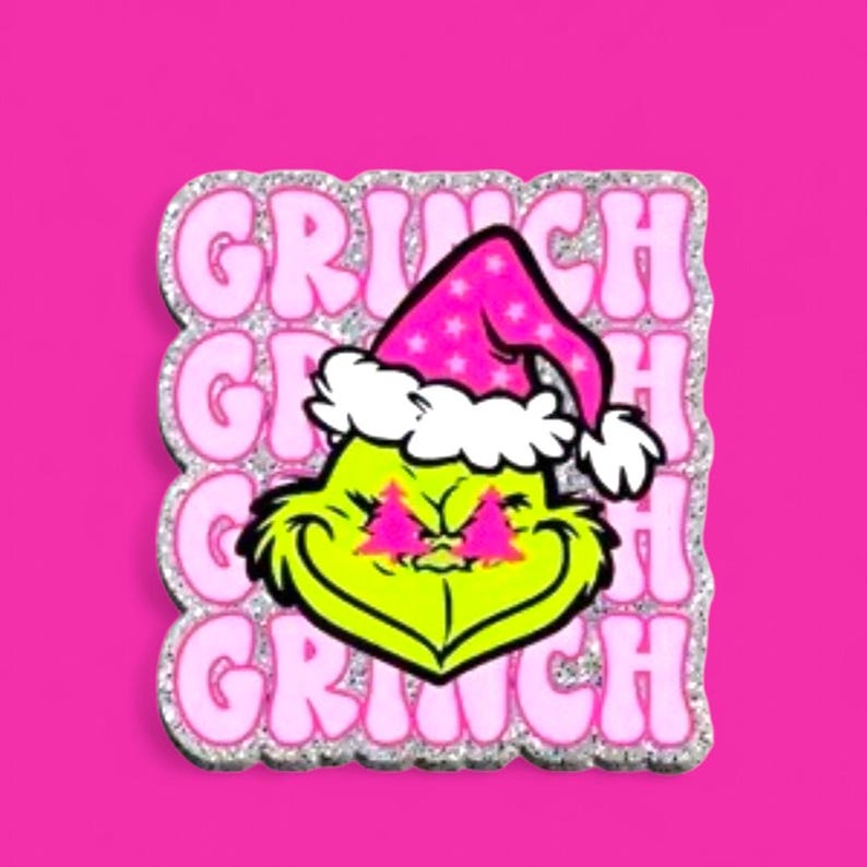 Pu&ograve; includere: Un adesivo quadrato raffigurante il volto di un personaggio verde lime che indossa un cappello da Babbo Natale rosa con stelle e bordo bianchi. Il personaggio ha occhi rosa a forma di albero di Natale. La parola GRINCH &egrave; ripetuta in rosa chiaro su uno sfondo glitterato argento.