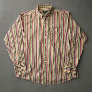 May include: A long-sleeve button-down shirt featuring a vertical striped pattern in shades of olive green, burgundy, yellow, and blue. The shirt includes a button-down collar, a single chest pocket, and white buttons running down the front placket.
