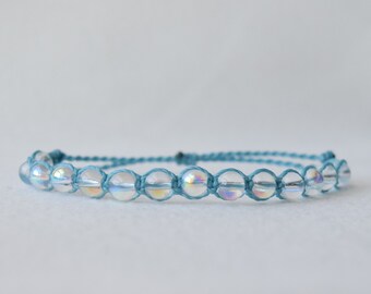 May include: A blue string bracelet with iridescent clear beads.