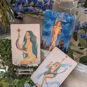 Puede incluir: Tres cartas de tarot con ilustraciones de mujeres e im&aacute;genes celestiales. Las cartas se titulan "Creatividad", "Libertad" y "La Luna".