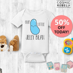 May include: White baby onesie with a blue jelly bean cartoon and the text "Our Little Jelly Bean".