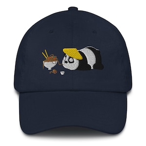 Può includere: Un cappello da baseball blu navy con un'immagine ricamata di un panda che indossa un cappello giallo e guarda una ciotola di noodles. Il panda è sdraiato a pancia in giù con le zampe distese.