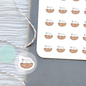 Puede incluir: Una hoja de 25 pegatinas con un difusor de aceite blanco en un cuenco de madera. Las pegatinas están diseñadas para su uso con difusores de aceites esenciales. El texto "Fox and Roe Ink." y "Difusor de aceite" está impreso en la hoja.