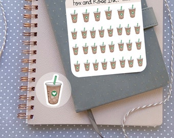 Peut inclure: Une feuille d'autocollants représentant 36 gobelets de café glacé bruns avec un couvercle vert et un cœur sur le côté. Les autocollants sont sur un fond blanc avec le texte "Fox and Rose Ink." en haut. Il y a aussi un seul autocollant représentant un gobelet de café glacé brun avec un couvercle vert et un cœur sur le côté.
