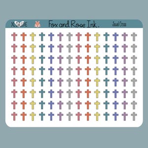 Puede incluir: Una hoja de pegatinas con múltiples diseños de cruces en varios colores, incluyendo naranja, amarillo, morado y gris. La hoja tiene el texto "XL DeLuxe", "Fox and Rose Ink." y "Jewel Cross".