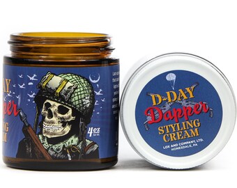 May include: A brown glass jar with a blue and white label featuring a skull wearing a helmet and holding a rifle. The label reads "D-Day Dapper Styling Cream" and "Lox and Company, LTD. Honesdale, PA".