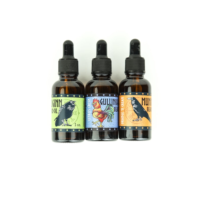May include: Three 1-ounce amber glass bottles with dropper tops. Each bottle has a different label with a colorful illustration and text. The labels read "Munkinn Beard Oil Citrus Crisp", "Gullink Beard Orange & Cream", and "Munkinn Beard Oil".