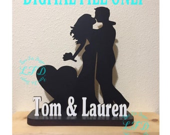 May include: Black silhouette of a couple kissing with a heart behind them. The couple are standing on a wooden base with the names "Tom & Lauren" written in white.