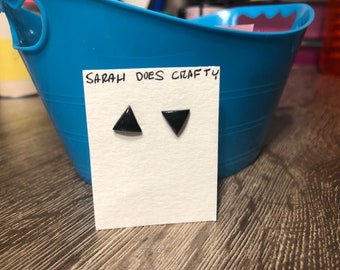 Puede incluir: Un par de pendientes de triángulo negro en una tarjeta blanca con el texto "SARAH DOES CRAFTY".