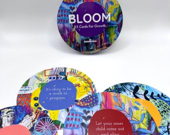 May include: A set of circular cards titled BLOOM 35 Cards For Growth, featuring vibrant abstract artwork in blue, yellow, and red. Each card displays unique motivational text such as It's okay to be a work in progress and Let your inner child come out and play.