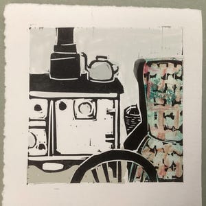 Puede incluir: Un grabado en linóleo en blanco y negro que representa una escena de cocina. El grabado presenta una estufa, una tetera y un objeto decorativo con acentos rosas y verdes. Una parte de una rueda es visible en primer plano.