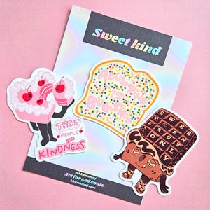 Puede incluir: Tres pegatinas coloridas con personajes de dibujos animados. La primera pegatina es un pastel rosa con una cereza en la parte superior y el texto "Treat people with kindness". La segunda pegatina es una rebanada de tostada con el texto "Adulting is just busy work". La tercera pegatina es una barra de chocolate con el texto "Sweet energy only".